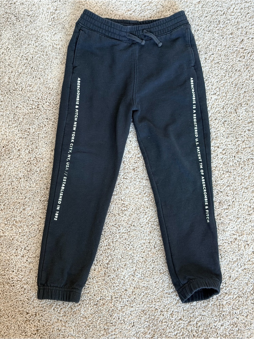 abercrombie kids black jogger pants with white side text